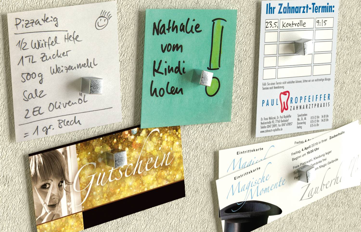 Porte de réfrigérateur avec cinq aimants tenant des notes, une liste de courses, un rappel « Nathalie vom Kindi holen », une carte de rendez-vous dentaire et des cartes-cadeaux.