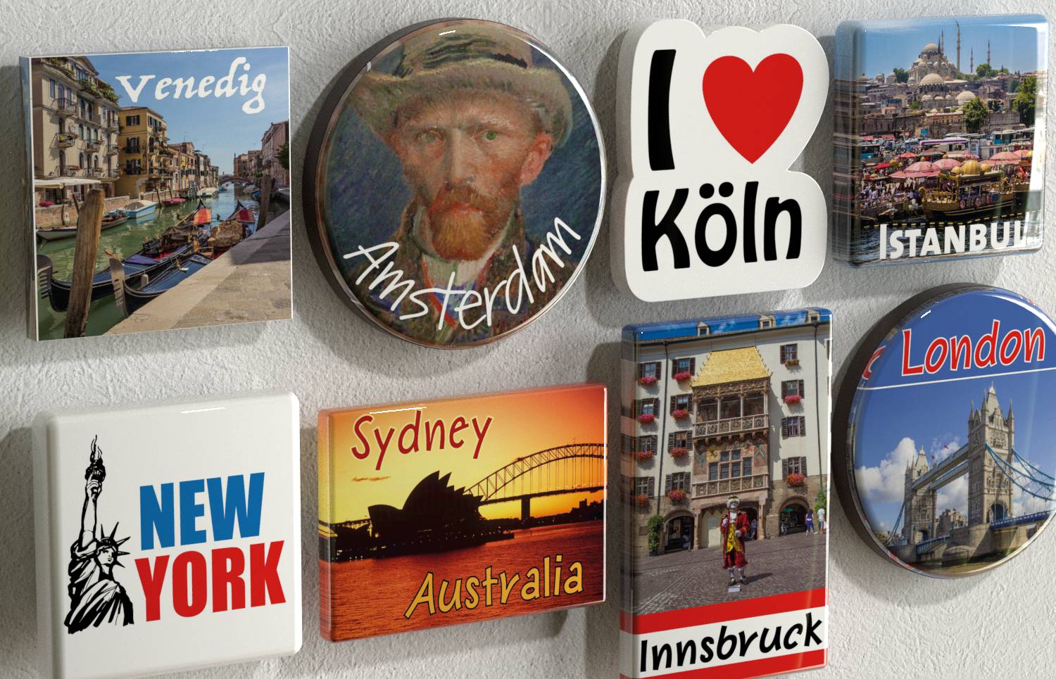 Un groupe d'aimants souvenirs représentant des destinations touristiques : Venise, Amsterdam, J'aime Cologne, Istanbul, New York, Sydney, Innsbruck et Londres.