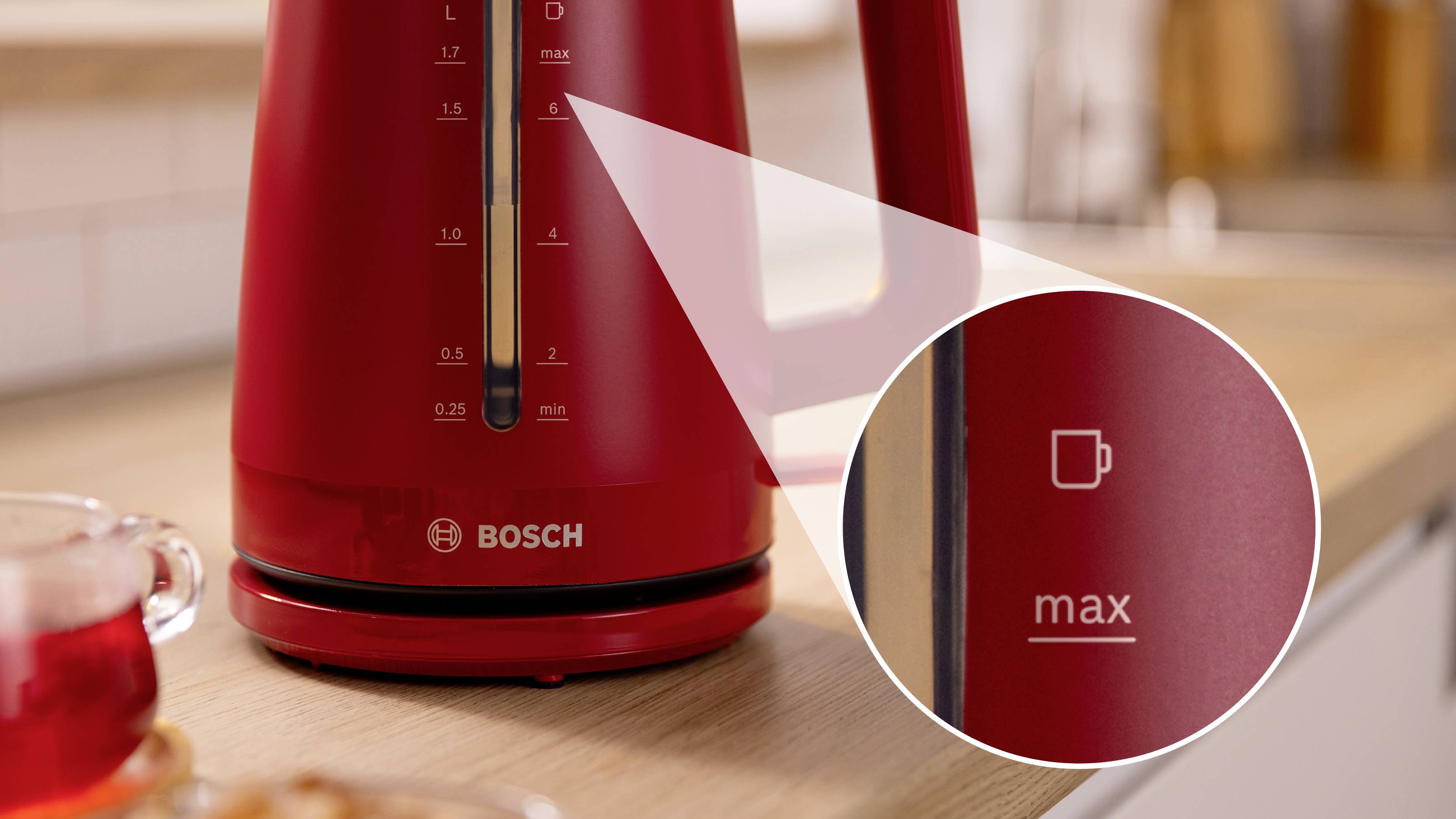 Bouilloire électrique rouge sur un comptoir de cuisine, montrant un gros plan de l'indicateur de niveau d'eau maximal 'max' à côté d'un symbole de tasse.