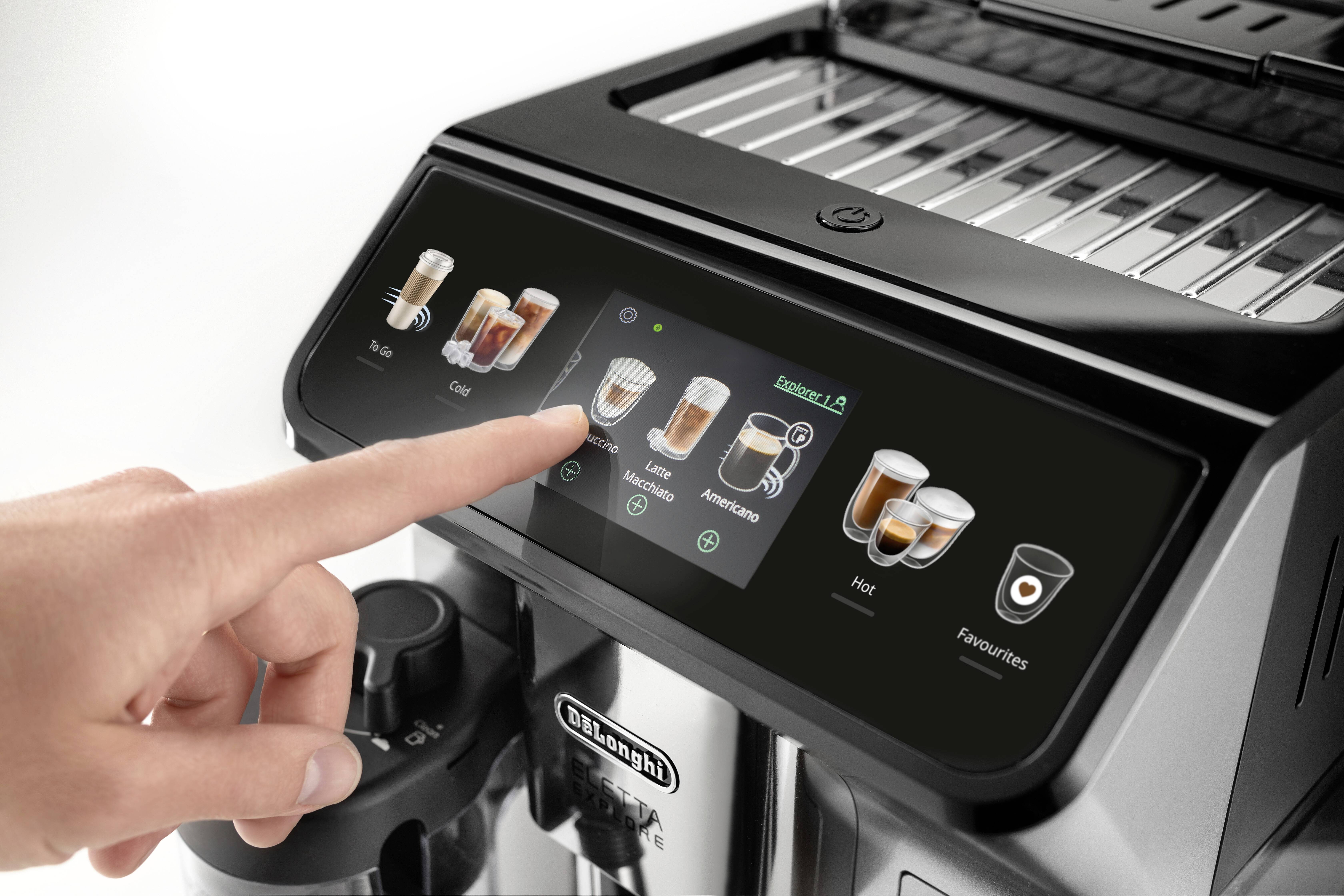 Un doigt sélectionne une option de café sur l'écran tactile d'une machine à café moderne. L'interface affiche différents types de café et réglages.