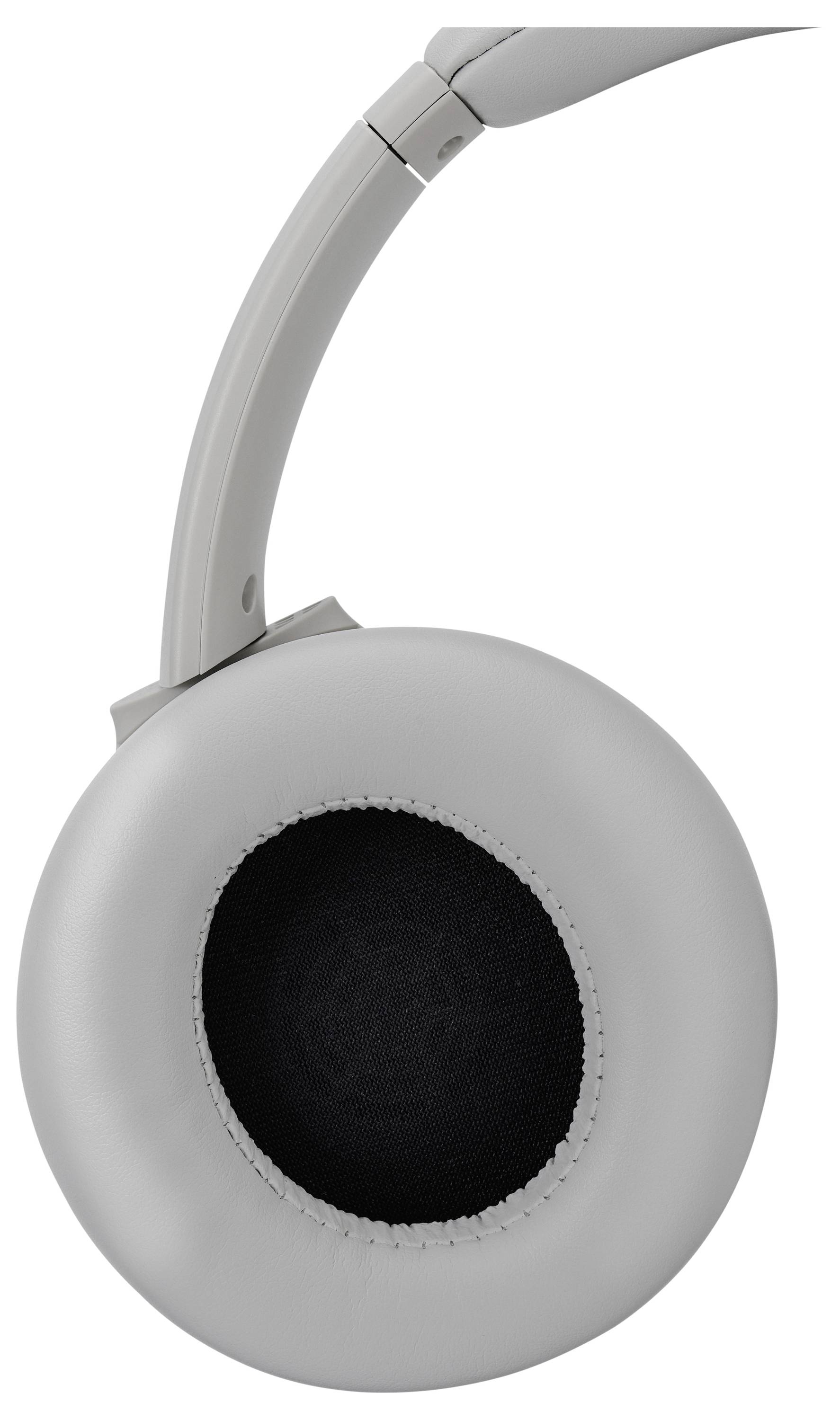 Une image en gros plan d'un écouteur de casque gris, montrant la surface extérieure rembourrée et la zone intérieure de haut-parleur avec un maillage noir.