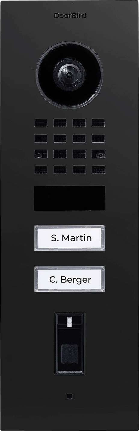 Un interphone DoorBird noir avec caméra, grille de haut-parleur et deux boutons étiquetés « S. Martin » et « C. Berger » sur un design épuré.