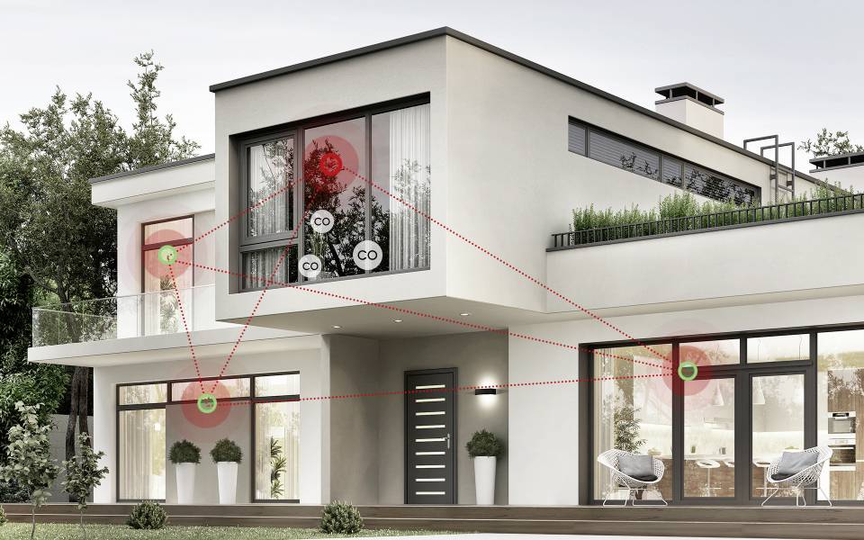 Maison moderne à deux étages avec plusieurs capteurs 'CO' marqués en rouge sur l'extérieur, indiquant les emplacements pour la détection du monoxyde de carbone.
