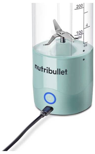 Un blender Nutribullet turquoise avec un gobelet doseur, un bouton marche visible et un cordon d'alimentation branché.