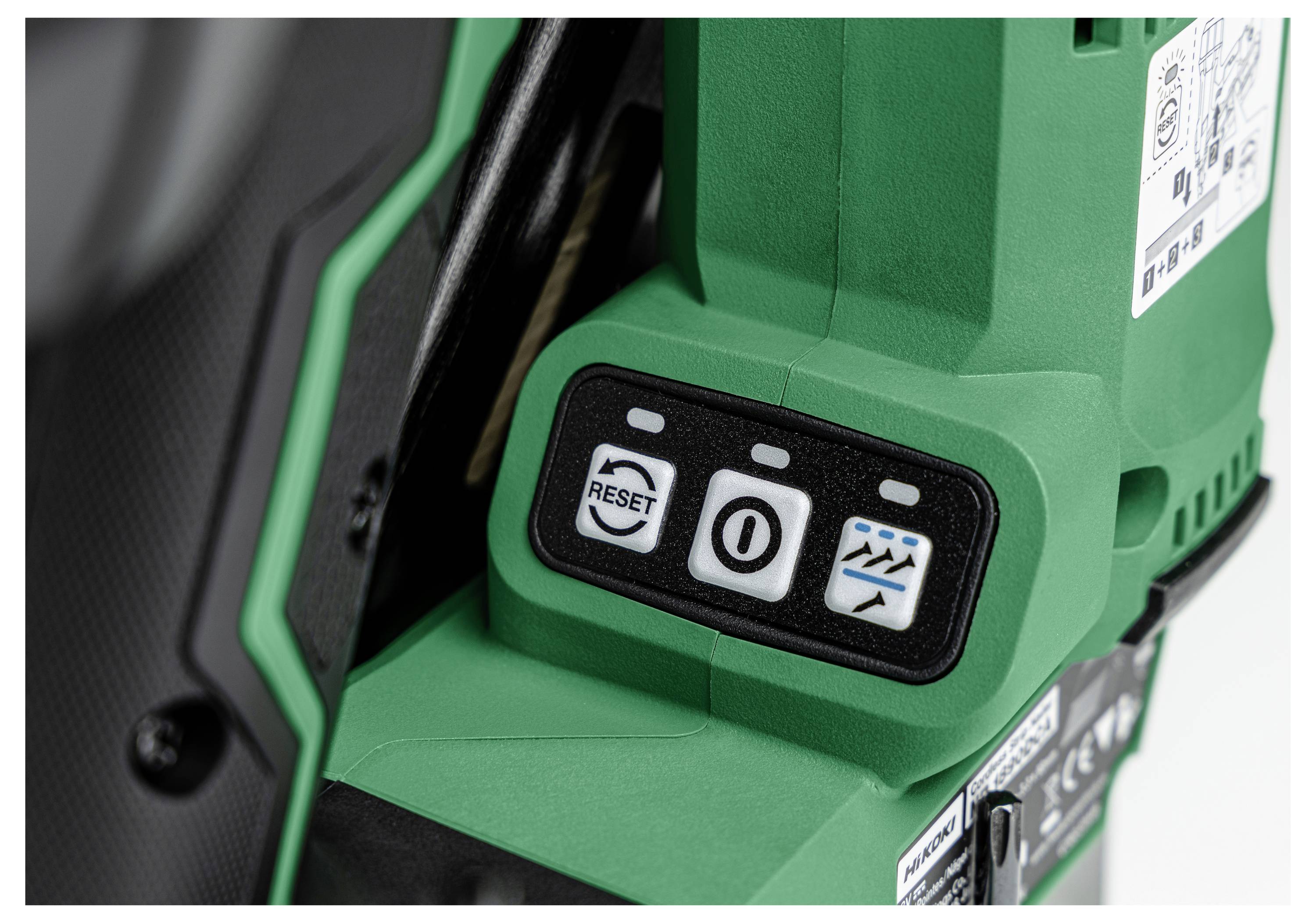 Gros plan sur un outil électrique vert avec des boutons de commande visibles étiquetés « RÉINITIALISER », « O » et une icône de cascade sur une pente.