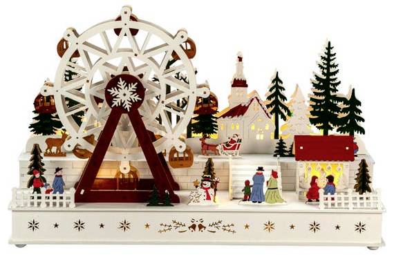 Scène de village sur le thème des fêtes avec une grande roue, des arbres environnants, des personnages et des maisons illuminées, évoquant une atmosphère festive.