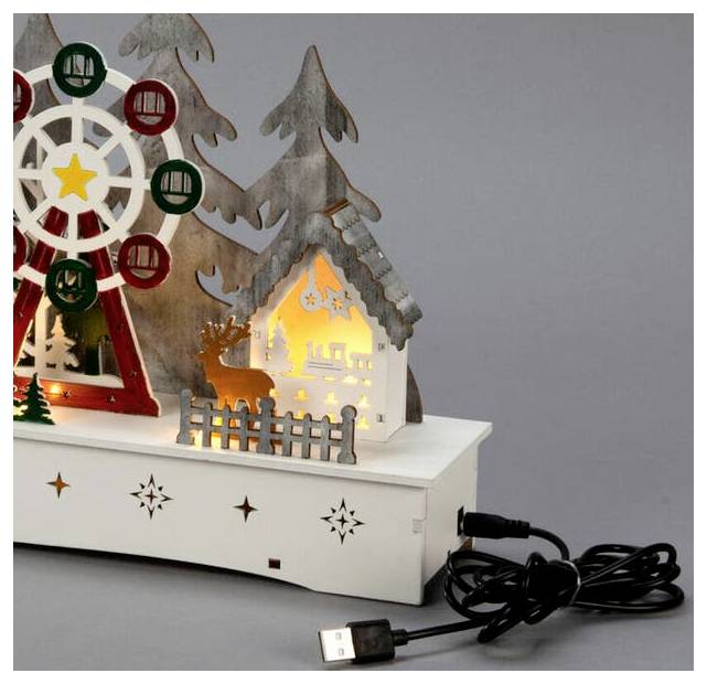 Un ornement décoratif en bois représente une grande roue illuminée, des arbres de Noël, un renne et une petite maison, avec un câble USB branché.