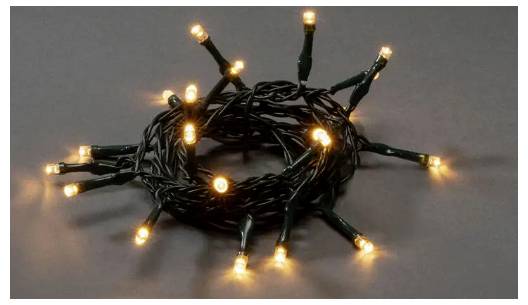 Une guirlande de lumières LED blanc chaud enroulée sur une surface sombre, luisant doucement.