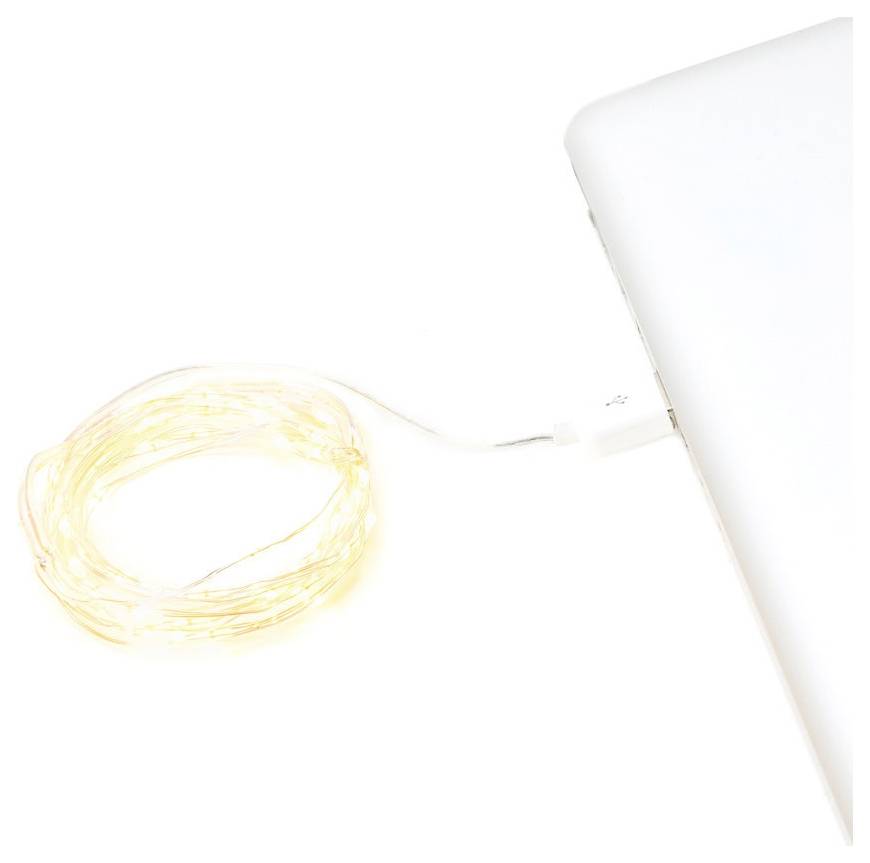 Un enroulement de fil de cuivre avec de petites lumières LED est branché sur le port USB d'un ordinateur portable, suggérant une source d'alimentation portable pour les lumières.