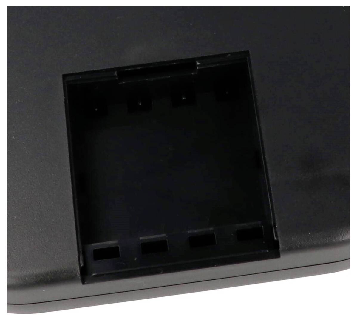 Un gros plan d'une surface en plastique noir avec une zone rectangulaire en creux contenant plusieurs fentes étroites, probablement destinées à des connexions électroniques.