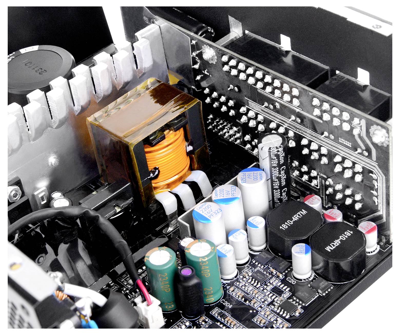 Vue interne d'une alimentation d'ordinateur montrant des condensateurs, des inducteurs et des composants de circuit imprimé, illustrant la conception électronique.