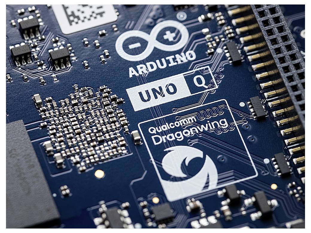 Gros plan sur un circuit imprimé bleu portant les logos « Arduino UNO Q » et « Qualcomm Dragonwing », mettant en valeur l'intégration technologique.