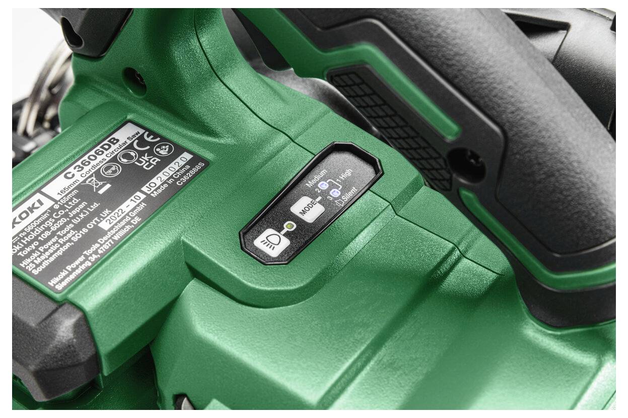 Un gros plan sur un outil électrique vert avec un interrupteur de commande, une étiquette de produit et du texte indiquant les instructions relatives à la batterie et à la sécurité.