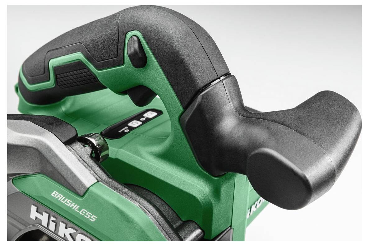 Vue rapprochée d'une poignée d'outil électrique vert et noir avec des boutons de commande visibles, conçue pour une utilisation ergonomique.