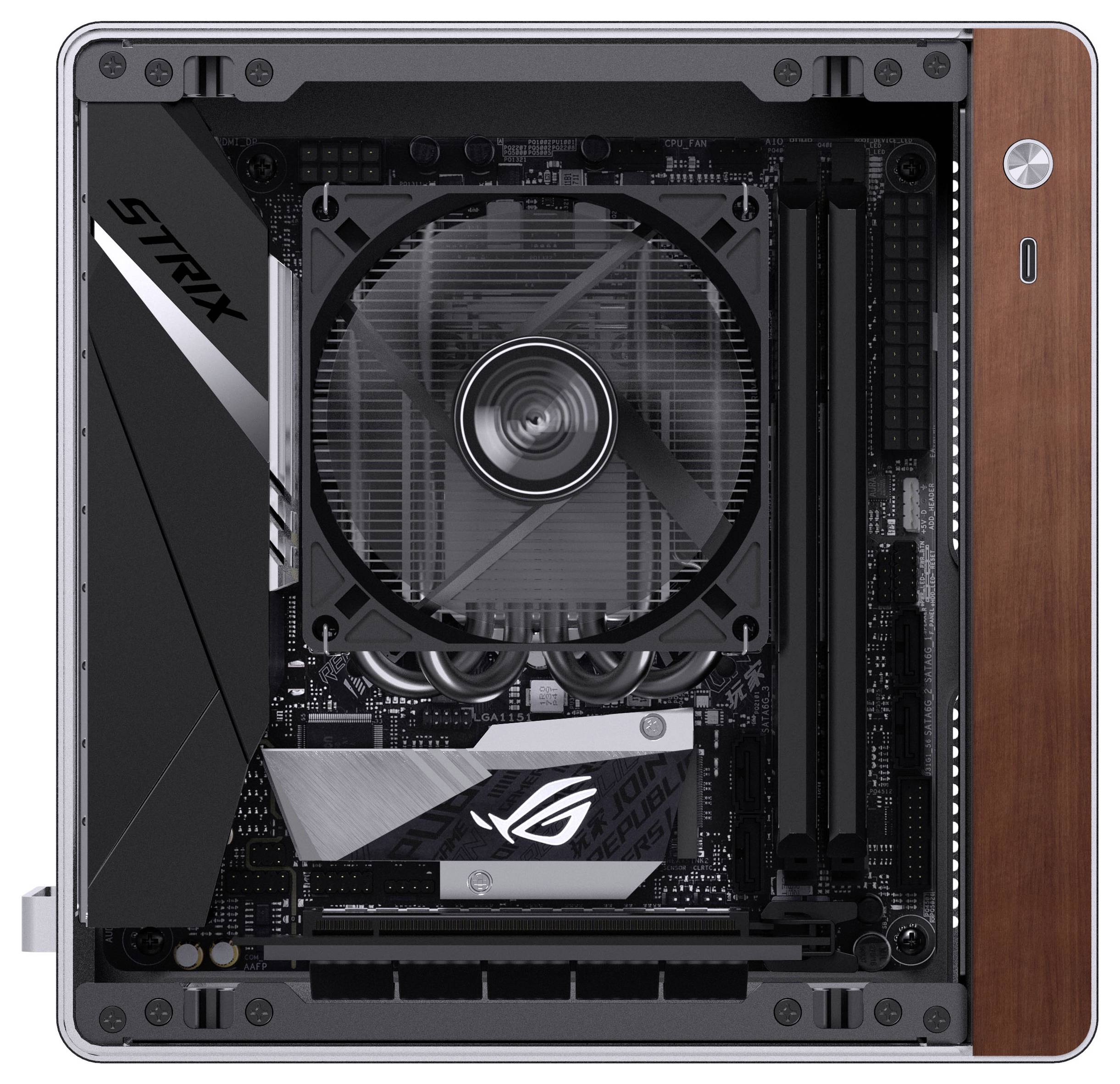 Une vue de dessus d'un PC de bureau avec un ventilateur de refroidissement central et des composants visibles, incluant un logo 'STRIX', dans un boîtier compact.