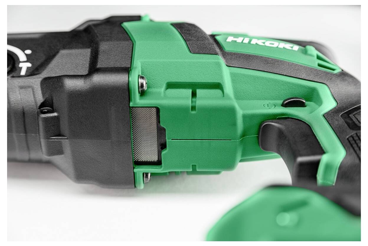 Gros plan sur un outil électrique vert et noir, centré sur sa poignée et une partie de son boîtier, révélant des détails tels que des vis et la marque du fabricant.