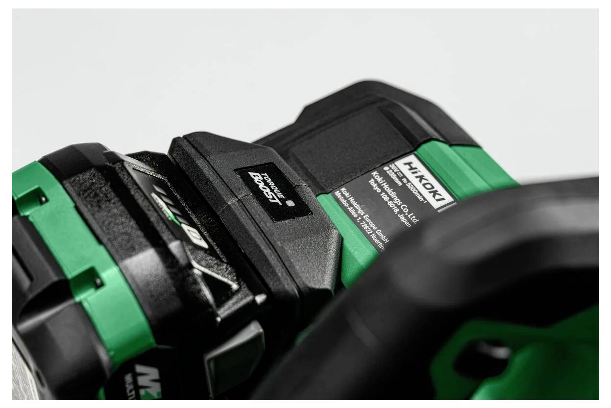 Gros plan d'une batterie d'outil électrique Hitachi dans un chargeur, montrant la marque 'Hikoki' et les spécifications sur l'étiquette, mettant en évidence le statut de charge.