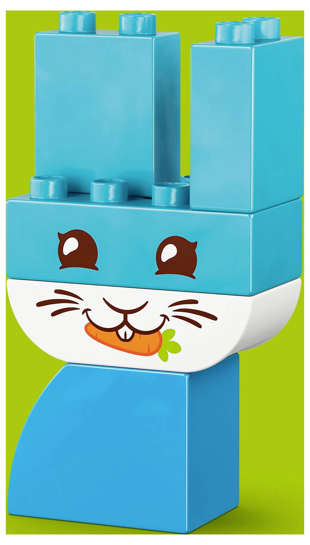 Une figurine en jouet faite de blocs de construction bleus ressemble à un lapin souriant avec une carotte dans la bouche, sur un fond vert.