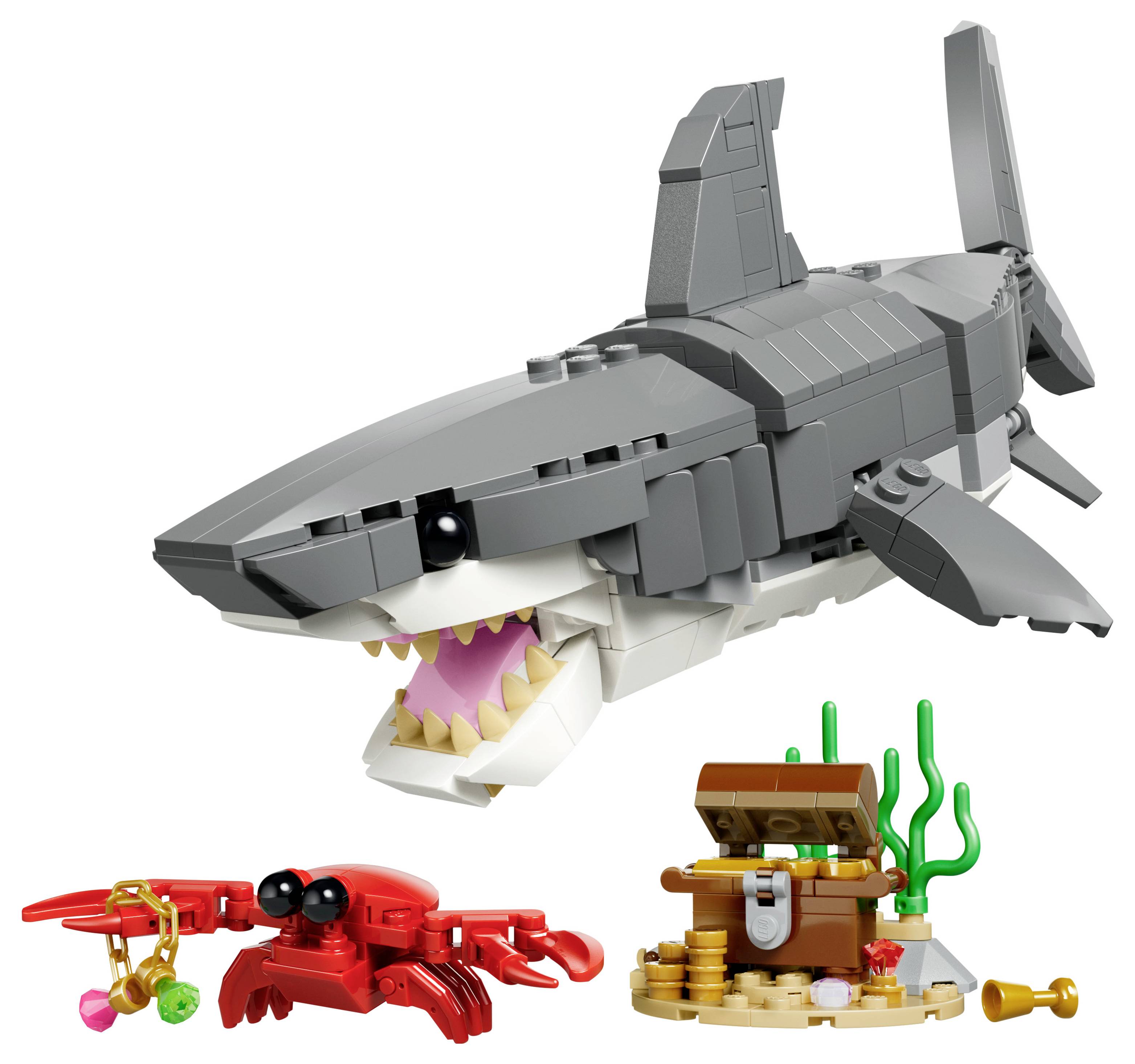 Un ensemble de jouets LEGO comprenant un requin détaillé, un crabe rouge tenant un objet rose, et un coffre au trésor avec des pièces de monnaie et des algues.