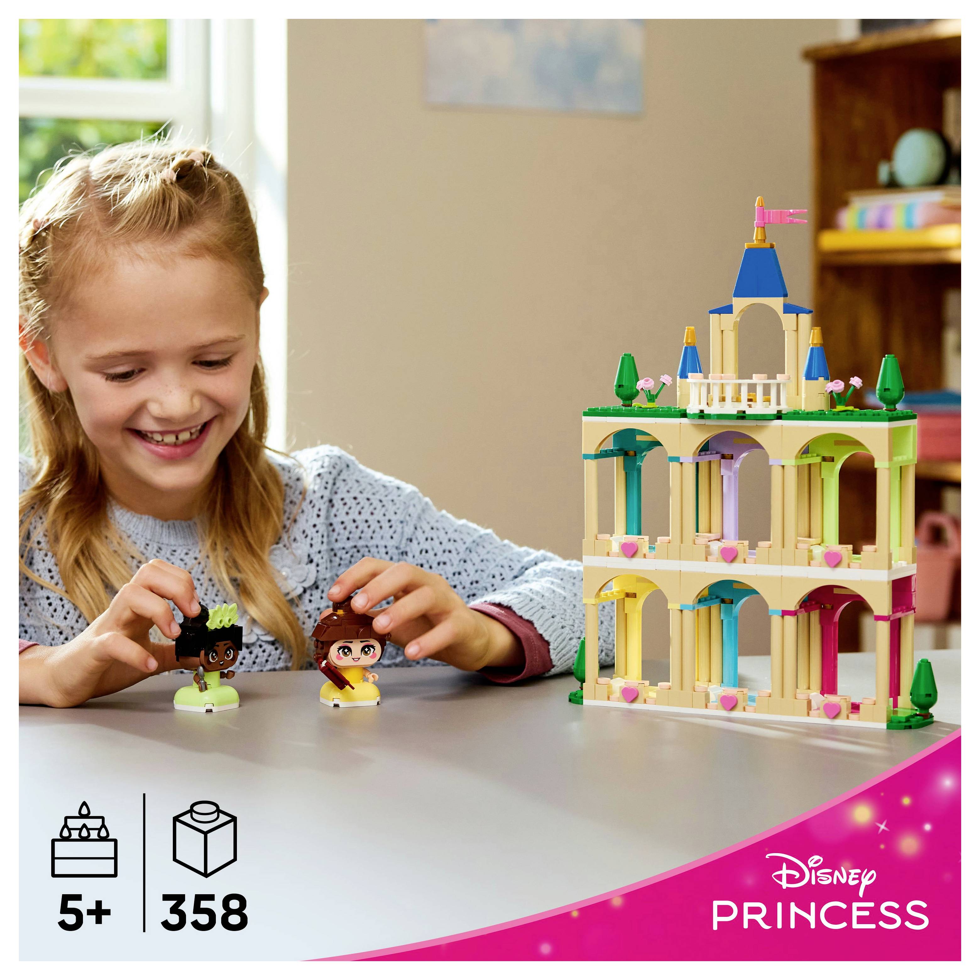 Un enfant joue avec des figurines miniatures à côté d'un ensemble de construction de château coloré étiqueté pour les âges 5 et plus, comprenant 358 pièces. La marque Disney Princess est visible.