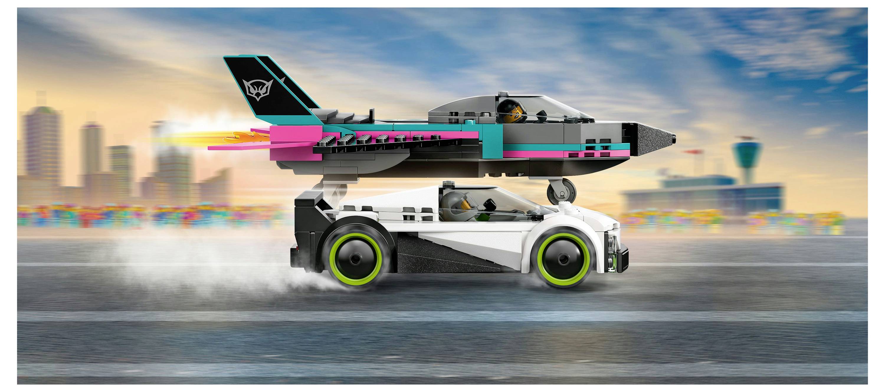 Une voiture de sport blanche avec des roues vertes file sur un circuit de course, transportant un jet coloré sur le toit. La ligne d'horizon de la ville est floue en arrière-plan.