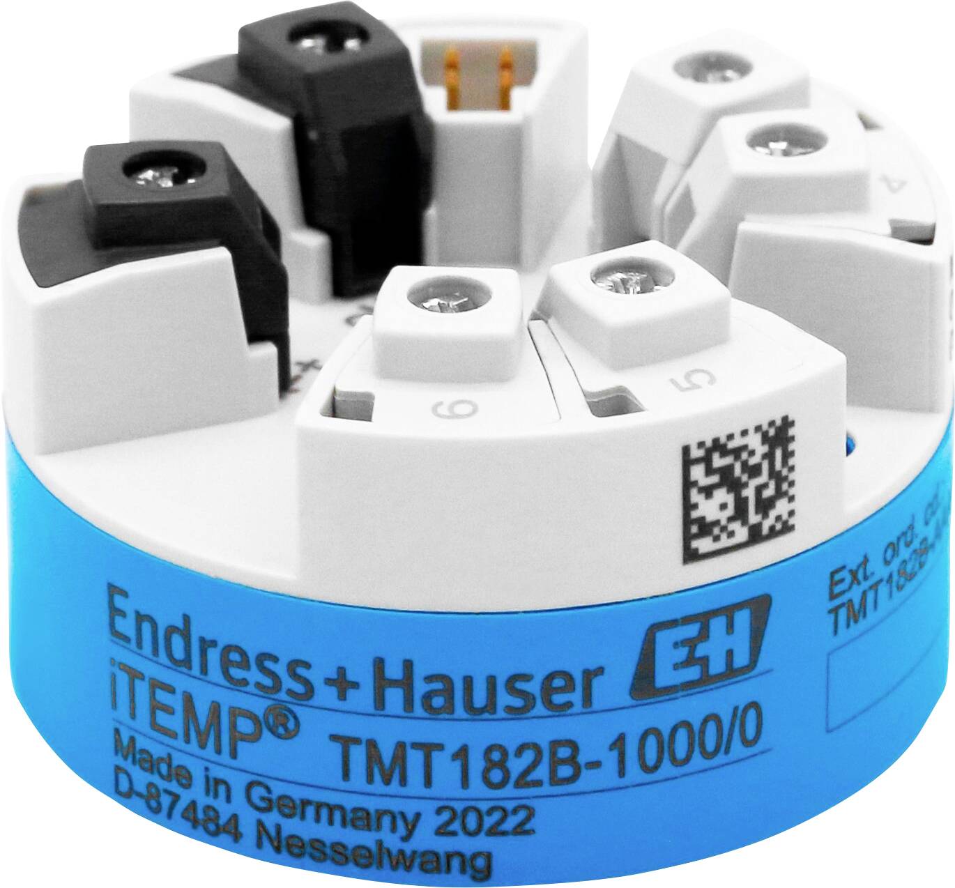Gros plan d'un transmetteur de température Endress+Hauser iTEMP TMT182B avec couvercle de terminal blanc et base étiquetée en bleu.