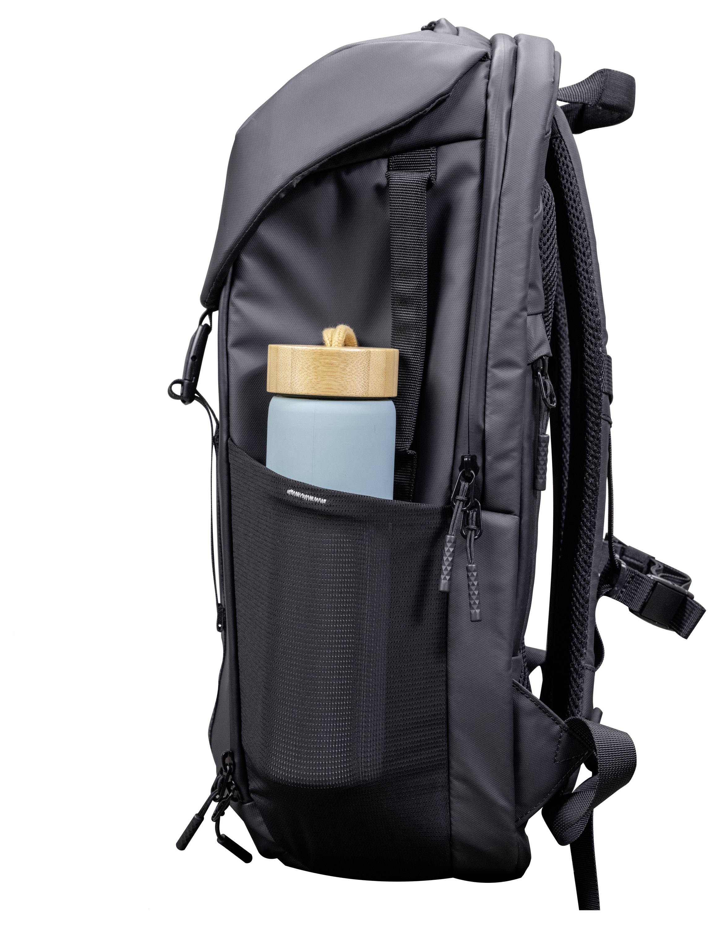 Un sac à dos noir doté d'une poche latérale en maille qui contient une bouteille d'eau bleue avec un couvercle en bois. Le sac à dos possède des bretelles rembourrées et plusieurs fermetures à glissière.