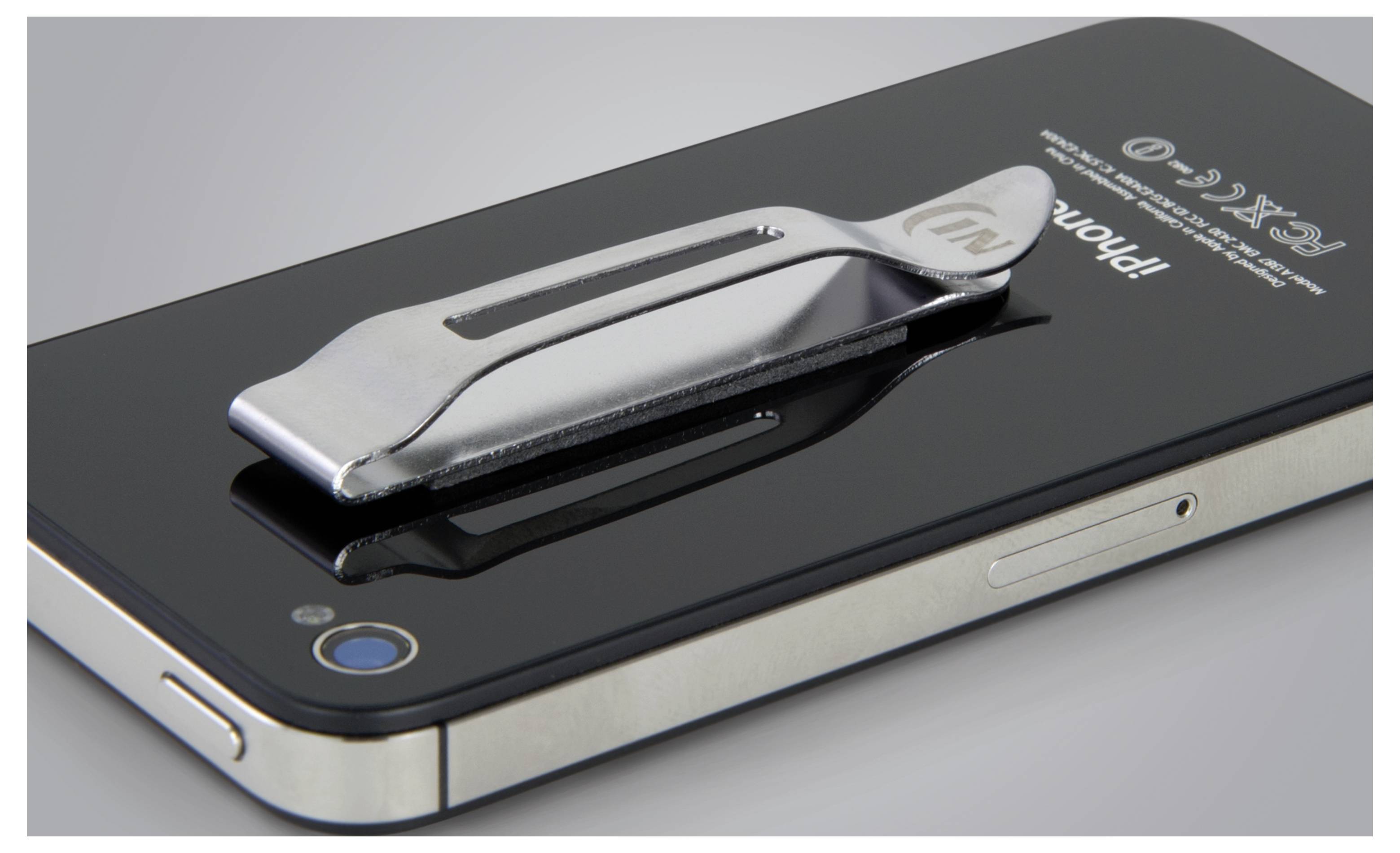 Un smartphone avec un clip métallique fixé à l'arrière, posé sur une surface plane. Le clip semble être un support pour stylet.