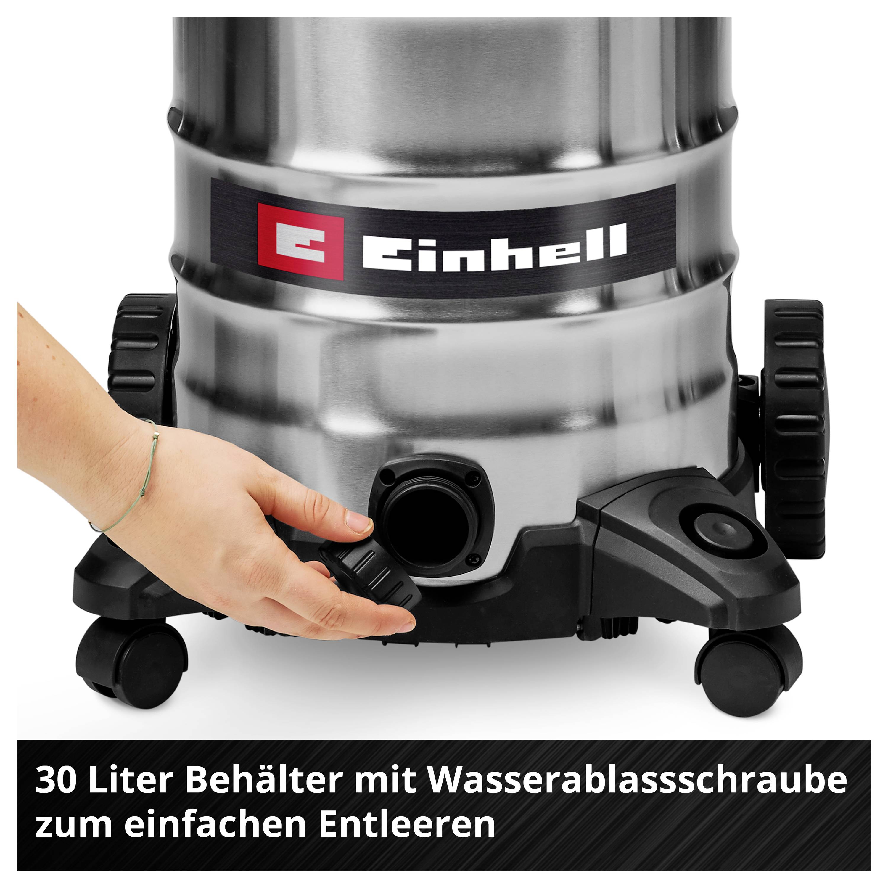 Des mains tournent la vis de vidange du réservoir de 30 litres de l'aspirateur sur roulettes, de la marque Einhell, pour le vider.