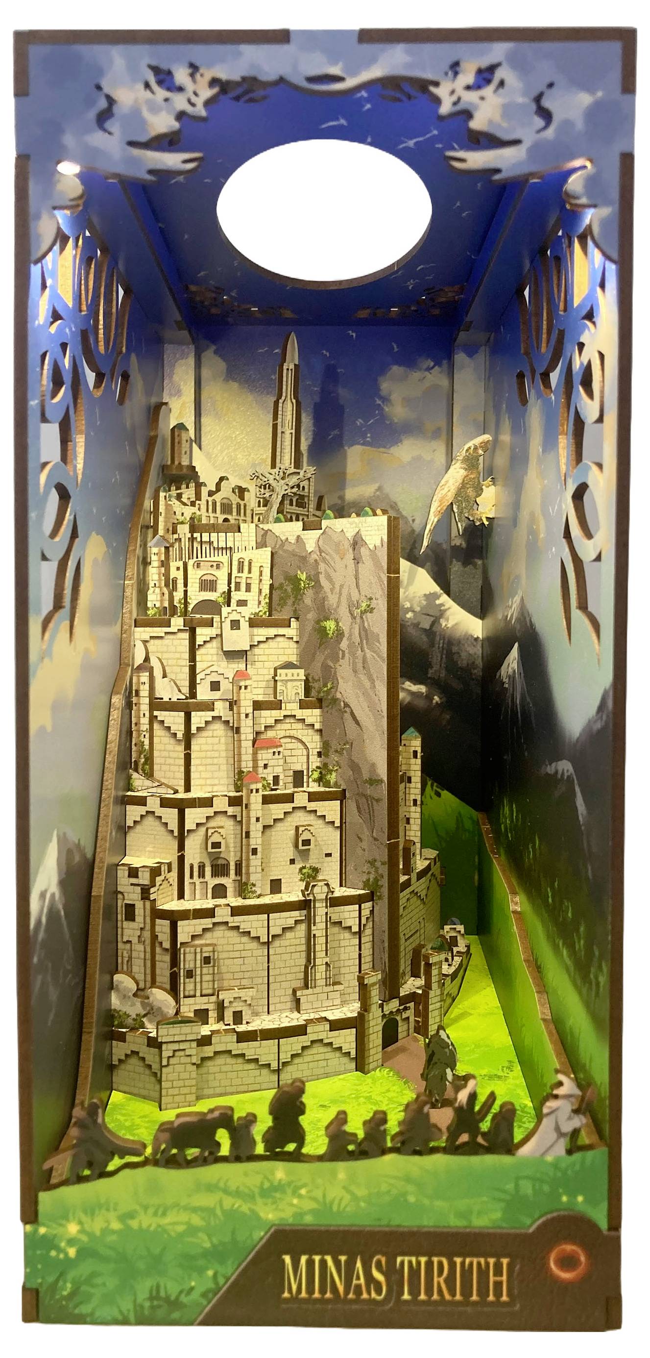 Diorama de Minas Tirith représentant un modèle détaillé d'une ville montagneuse à plusieurs niveaux, avec des remparts et des tours, sur un fond de ciel.