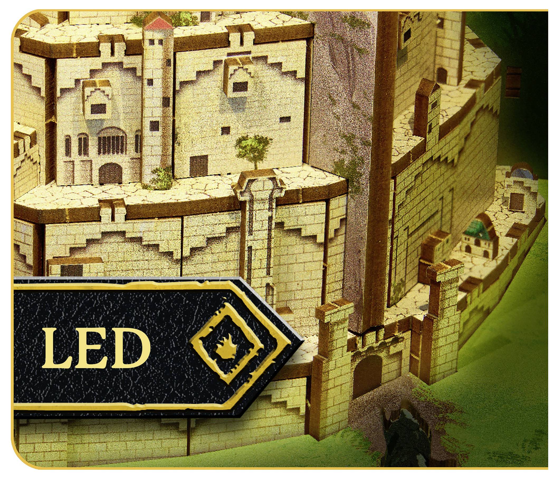 Une maquette détaillée d'un château médiéval avec un panneau 'LED' pointant vers lui ; le château possède des tours, des remparts et une base rocheuse.