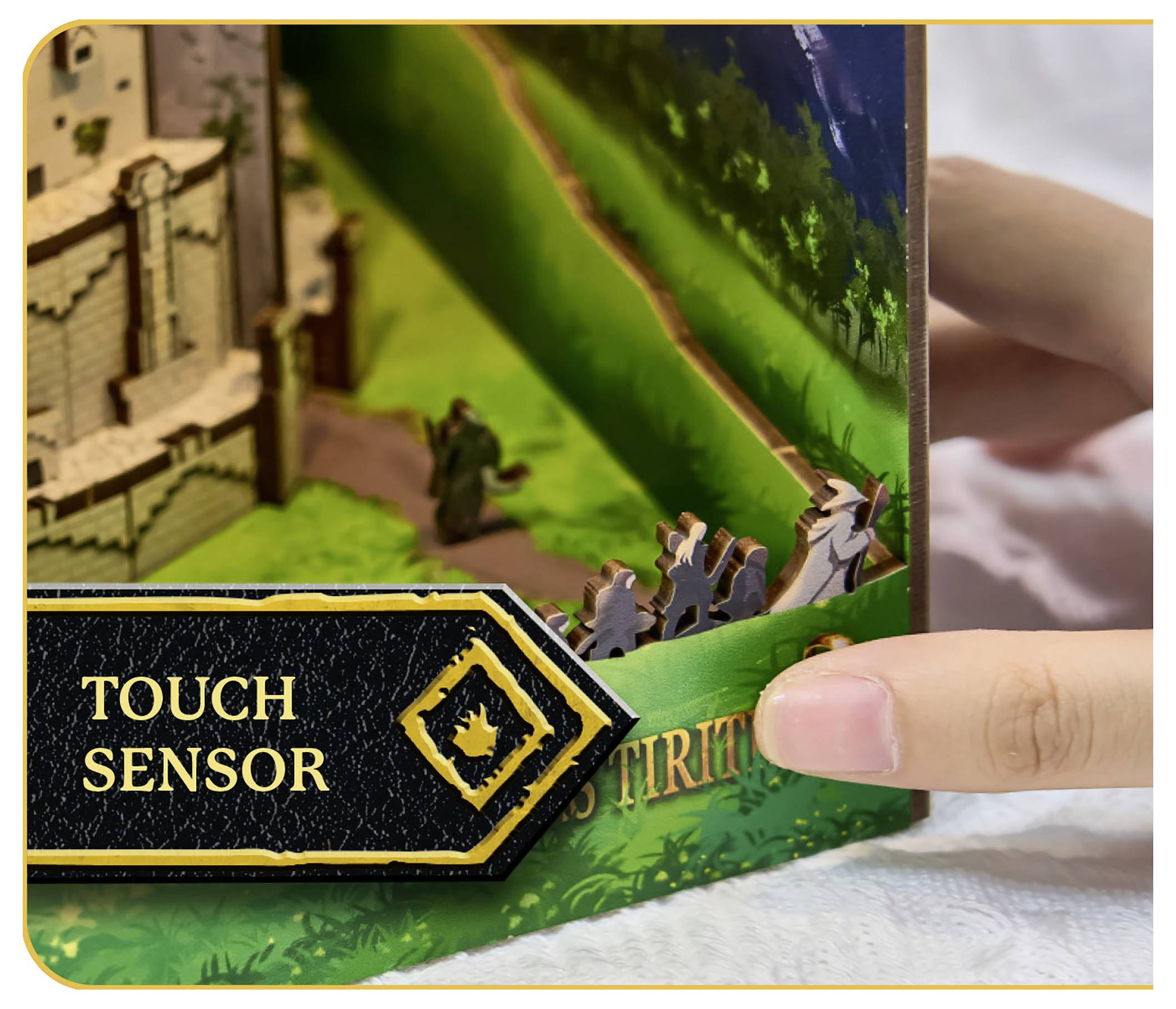 Une main touche une page d'un livre pop-up en 3D présentant une scène de château. La page comprend une étiquette « Capteur tactile » indiquant du contenu interactif.