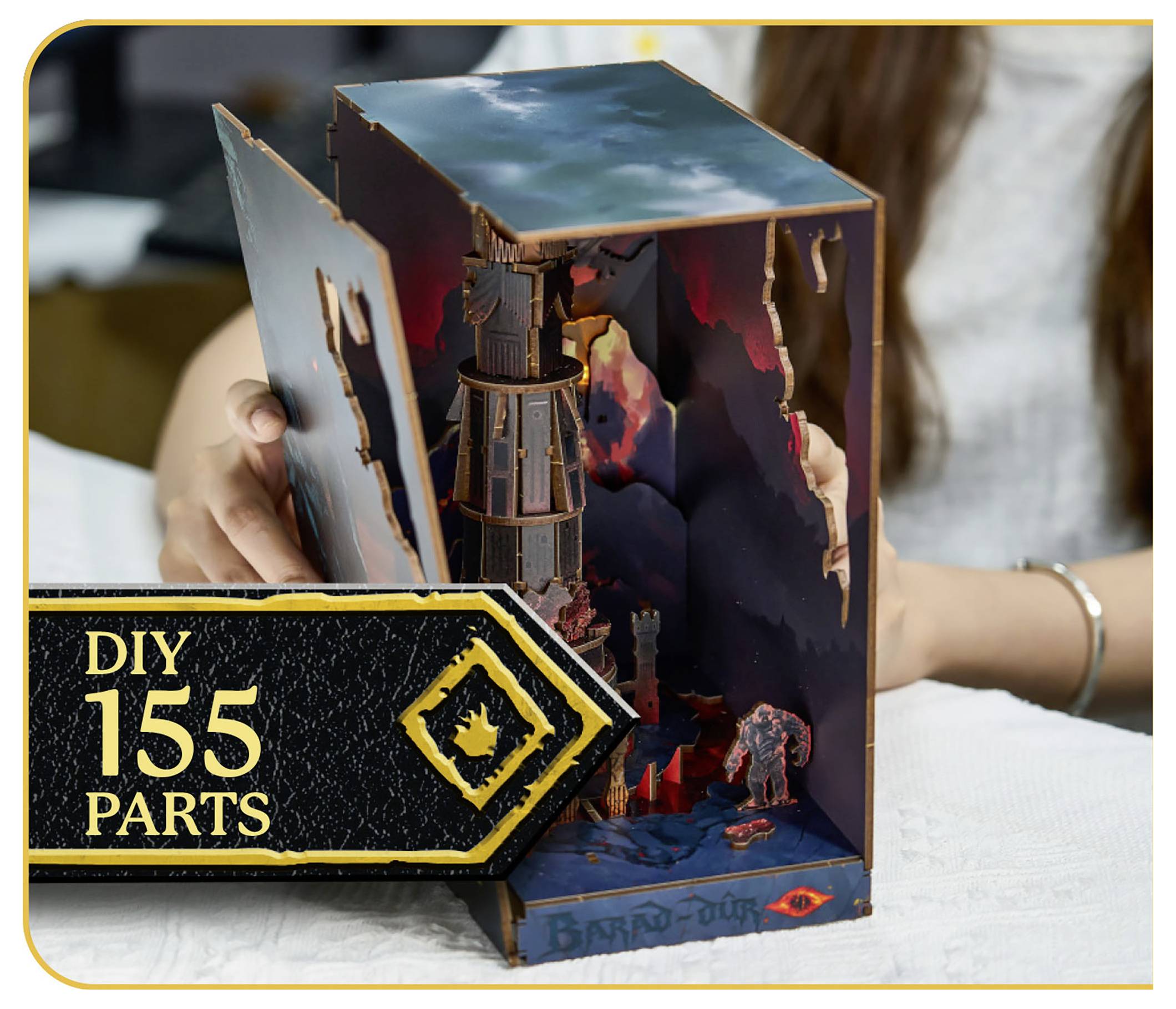 Une personne assemblant un modèle DIY 3D avec le texte « DIY 155 Pièces » en incrustation. Le modèle représente une tour et un paysage.