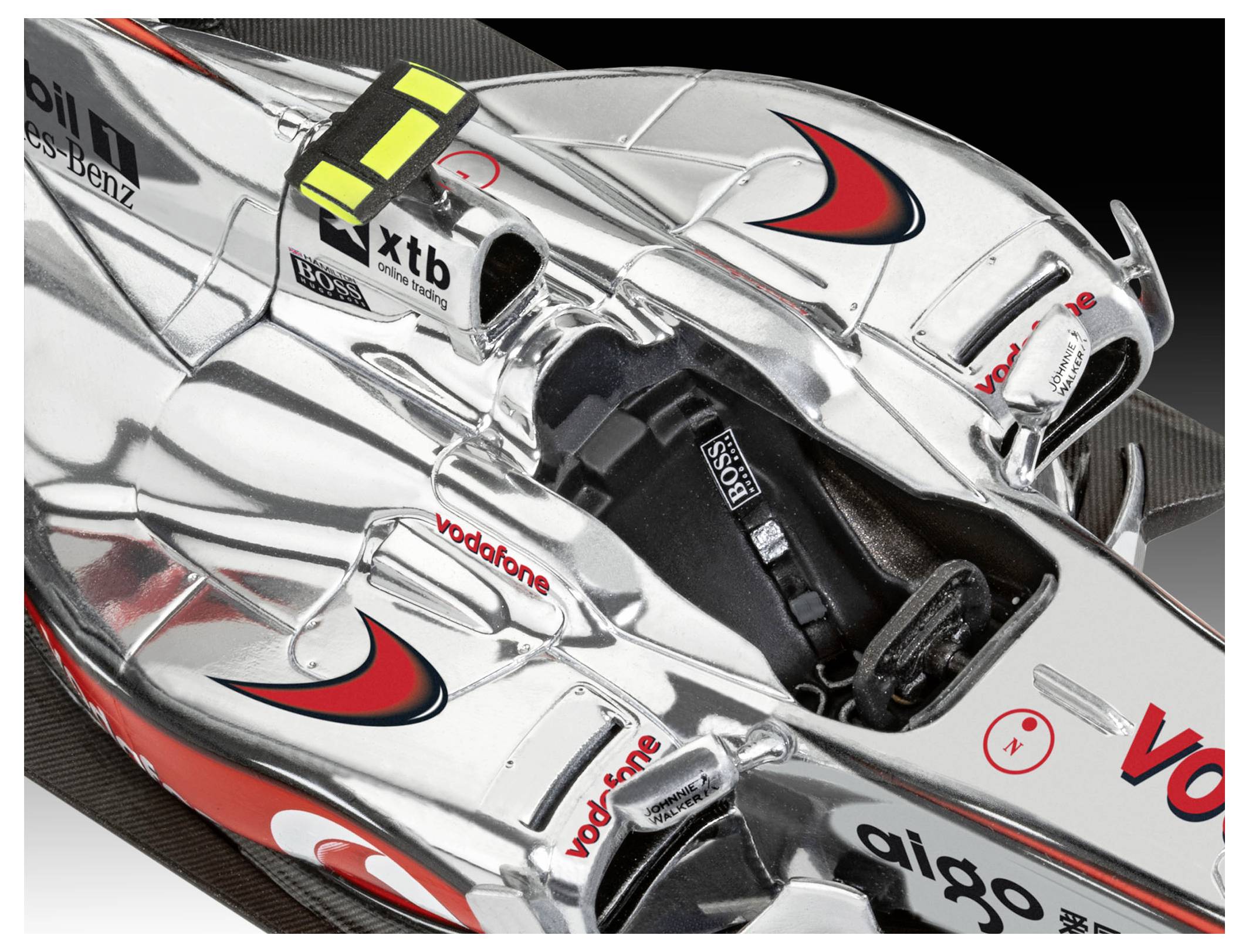 Une vue rapprochée détaillée du cockpit d'une voiture de Formule 1 élégante et argentée, mettant en valeur les logos de marques et les caractéristiques aérodynamiques.