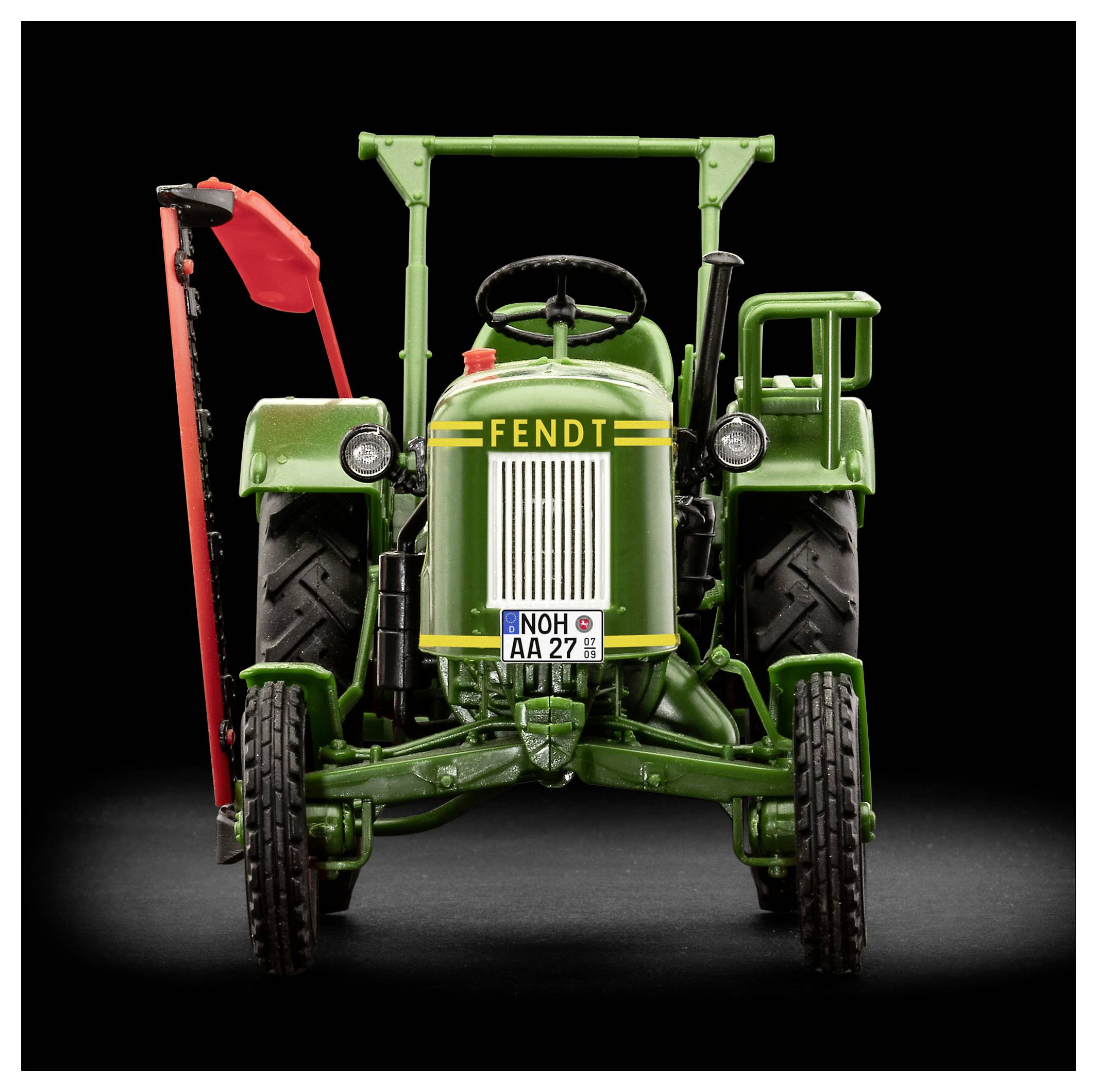 Un tracteur vintage vert avec le logo 'Fendt', vue de face, posé sur un fond sombre. Accents rouges sur le côté gauche, plaque d'immatriculation visible.
