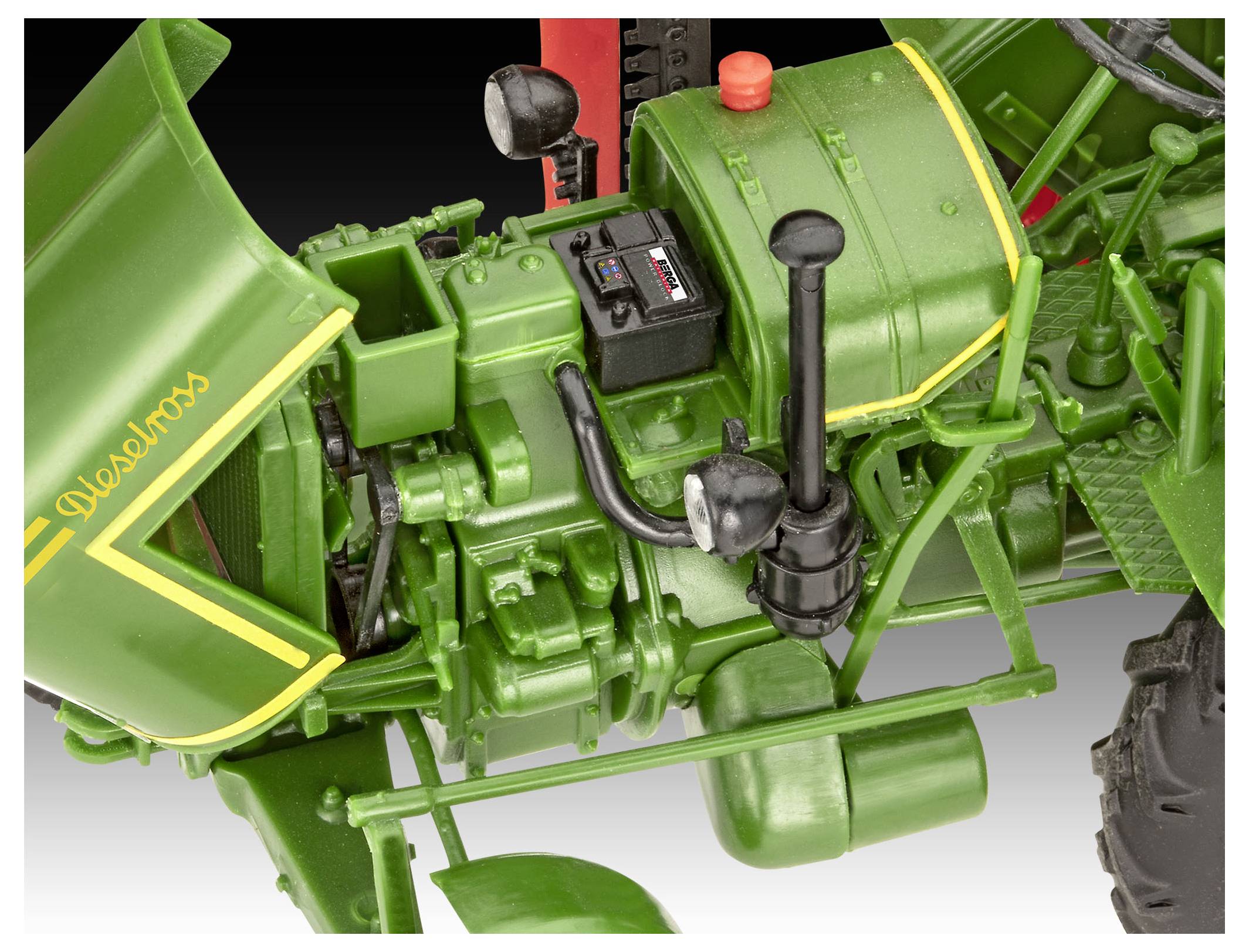 Gros plan sur les composants moteur détaillés d'un tracteur vintage vert, mettant en valeur des leviers, une boîte à outils et des pièces mécaniques au design complexe.