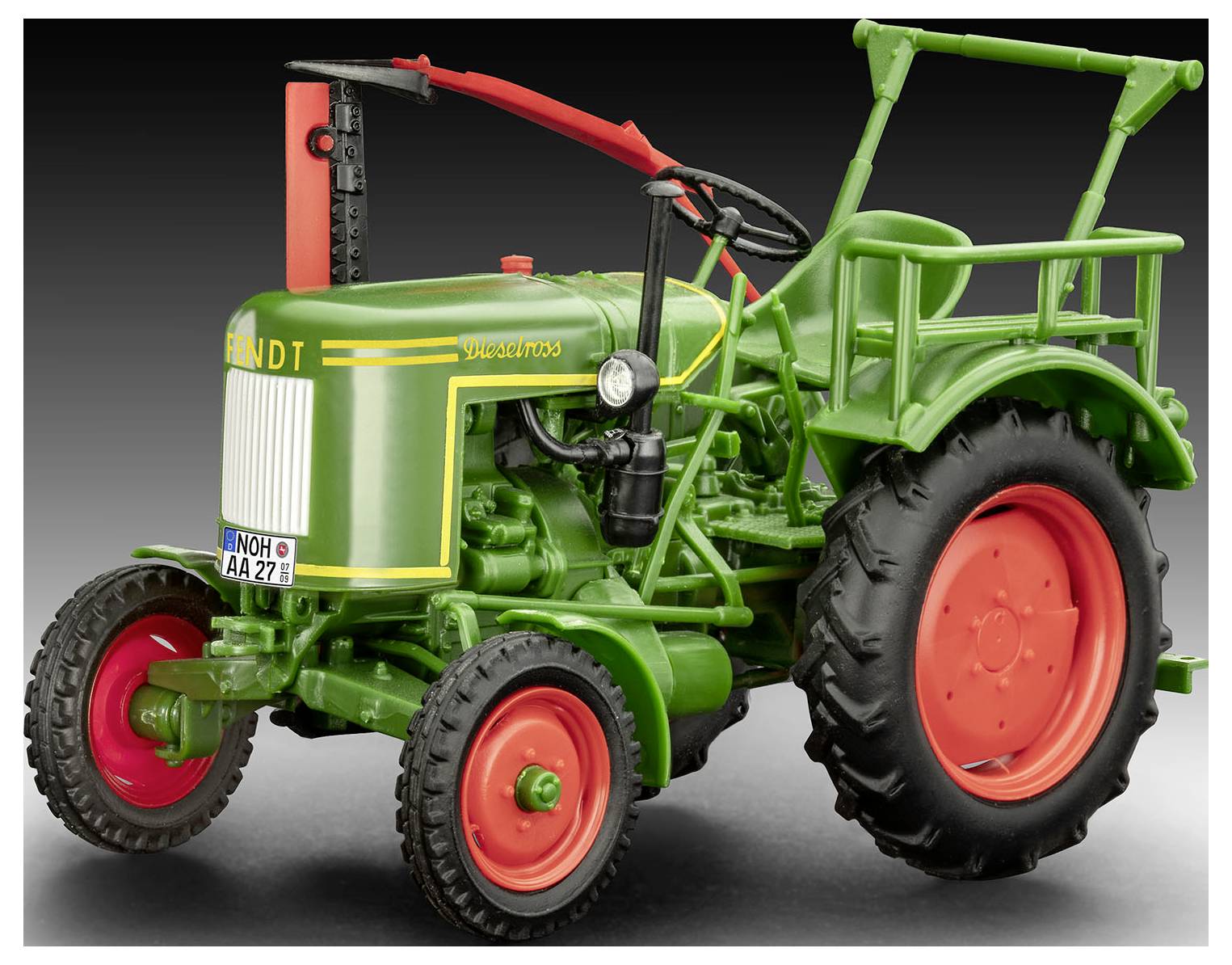 Un petit tracteur vintage vert et rouge, présenté de profil sur un fond dégradé noir, mettant en valeur son design classique.