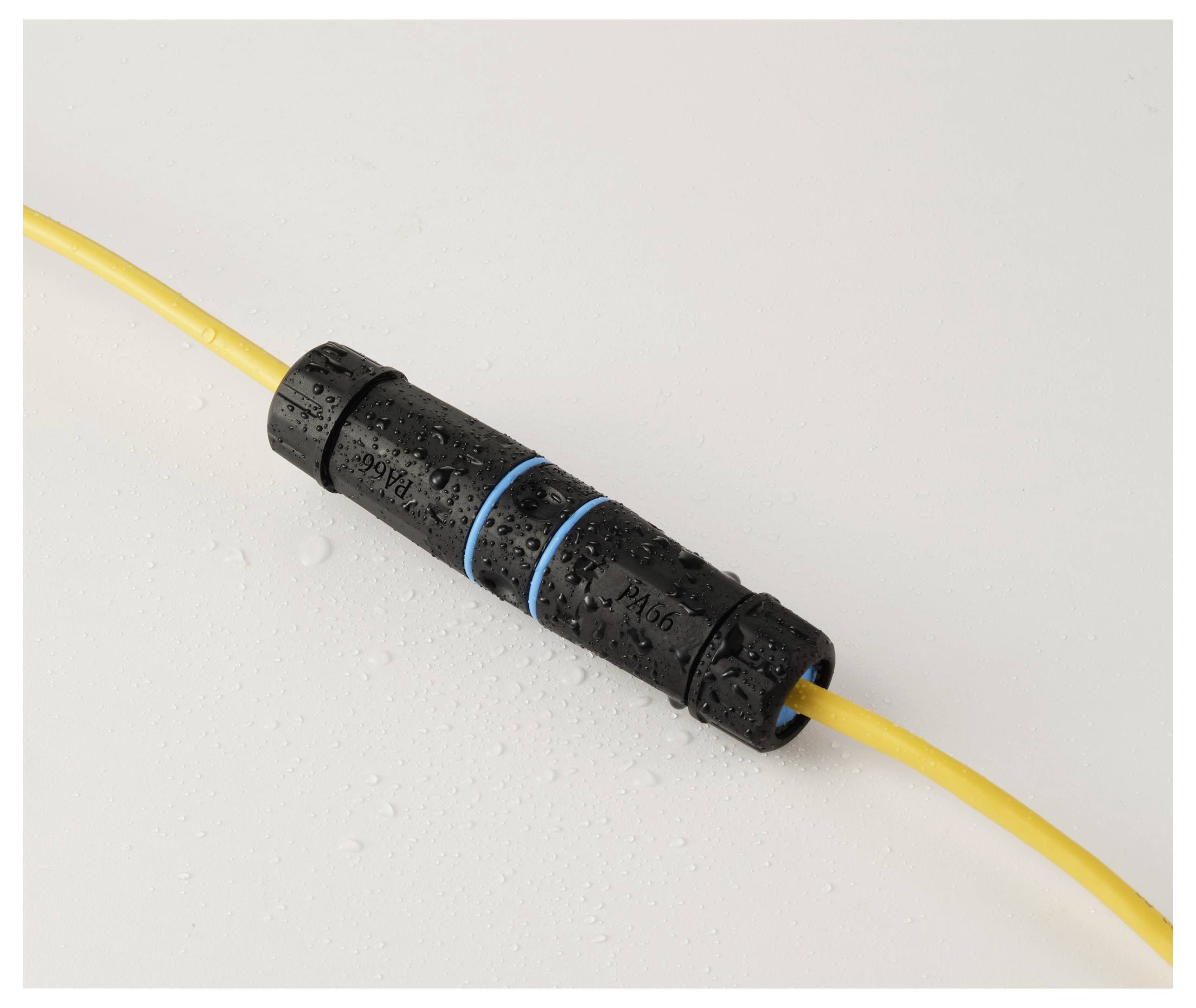 Un connecteur de câble noir étanche avec des bagues bleues relie deux câbles jaunes, entouré de gouttelettes d'eau, indiquant une résistance à l'eau.