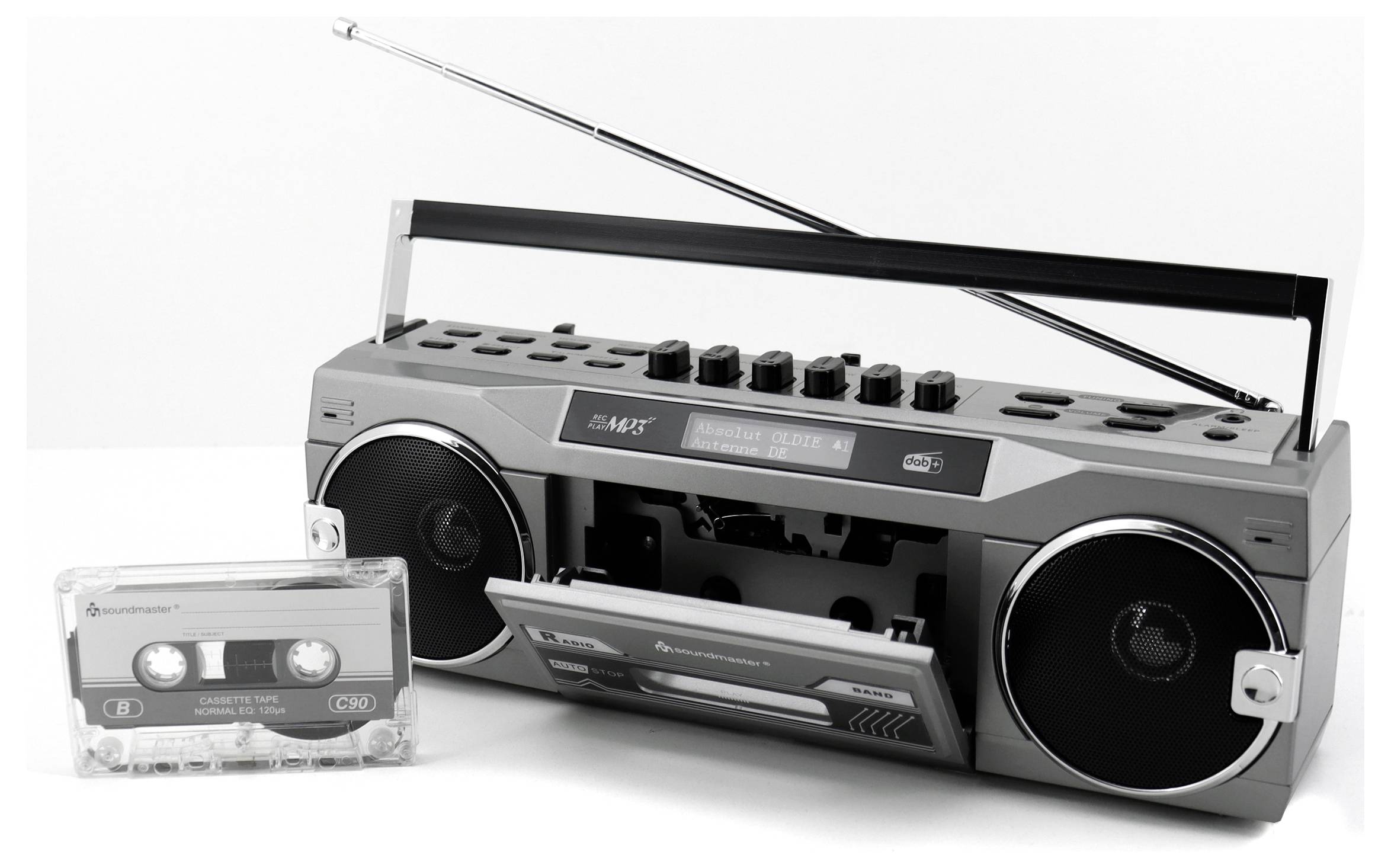 Un boombox de style rétro avec une antenne télescopique est posé à côté d'une cassette audio. Le boombox possède des enceintes rondes et un lecteur de cassettes.