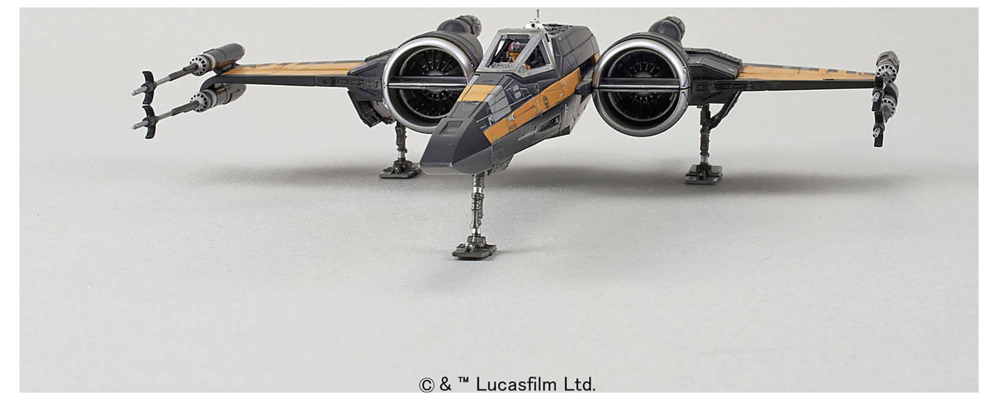 Un modèle d'un chasseur stellaire d'un film de science-fiction, avec un fuselage gris élégant et des touches d'orange, présenté sur un fond neutre.