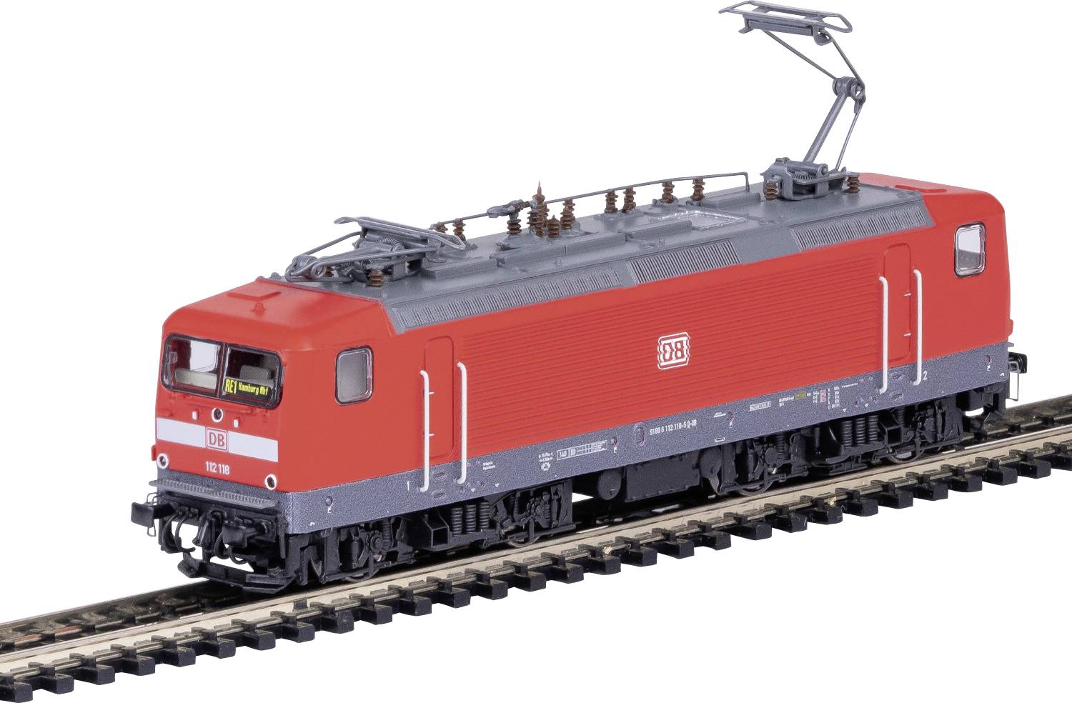 Une locomotive de train miniature rouge et grise sur des rails, présentant un équipement de toit détaillé et des roues réalistes, vue de côté.