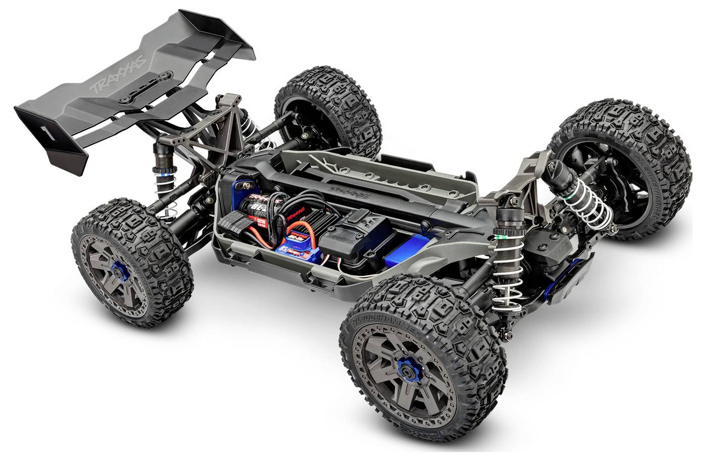 Une vue détaillée d'un châssis de voiture télécommandée tout-terrain, montrant de grandes roues, une suspension, un moteur et des composants électroniques, soulignant le design et la fonctionnalité.
