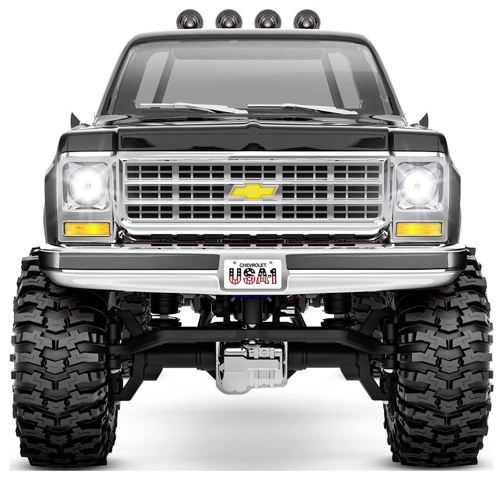Un camion Chevrolet noir robuste avec de grands pneus tout-terrain, une calandre imposante et des phares sur le toit. La plaque d'immatriculation affiche « USA1 ».