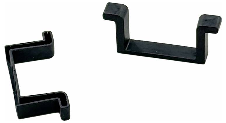 Deux crochets en plastique noir sur un fond blanc, chacun ayant une forme à angle droit et des rainures pour une meilleure préhension, utilisés pour fixer ou maintenir des objets.