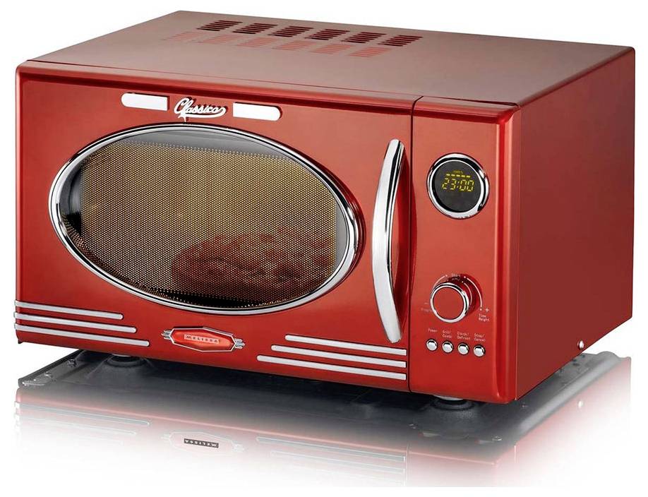 Un four à micro-ondes rétro de couleur rouge, doté d'un affichage numérique de l'horloge indiquant « 23:00 », une porte vitrée ronde et plusieurs boutons de contrôle.