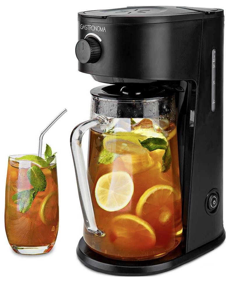 Fabricant de thé glacé noir avec un pichet en verre rempli de thé glacé, des tranches de citron et des feuilles de menthe. Un verre de thé glacé avec de la menthe et du citron est posé à côté.