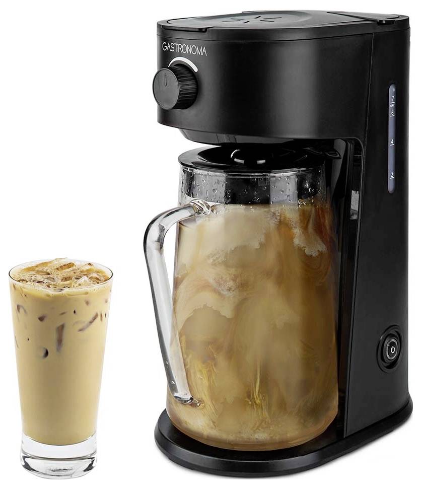 'Machine à café noire avec une carafe transparente à moitié remplie de café glacé, à côté d'un verre plein de café glacé.'