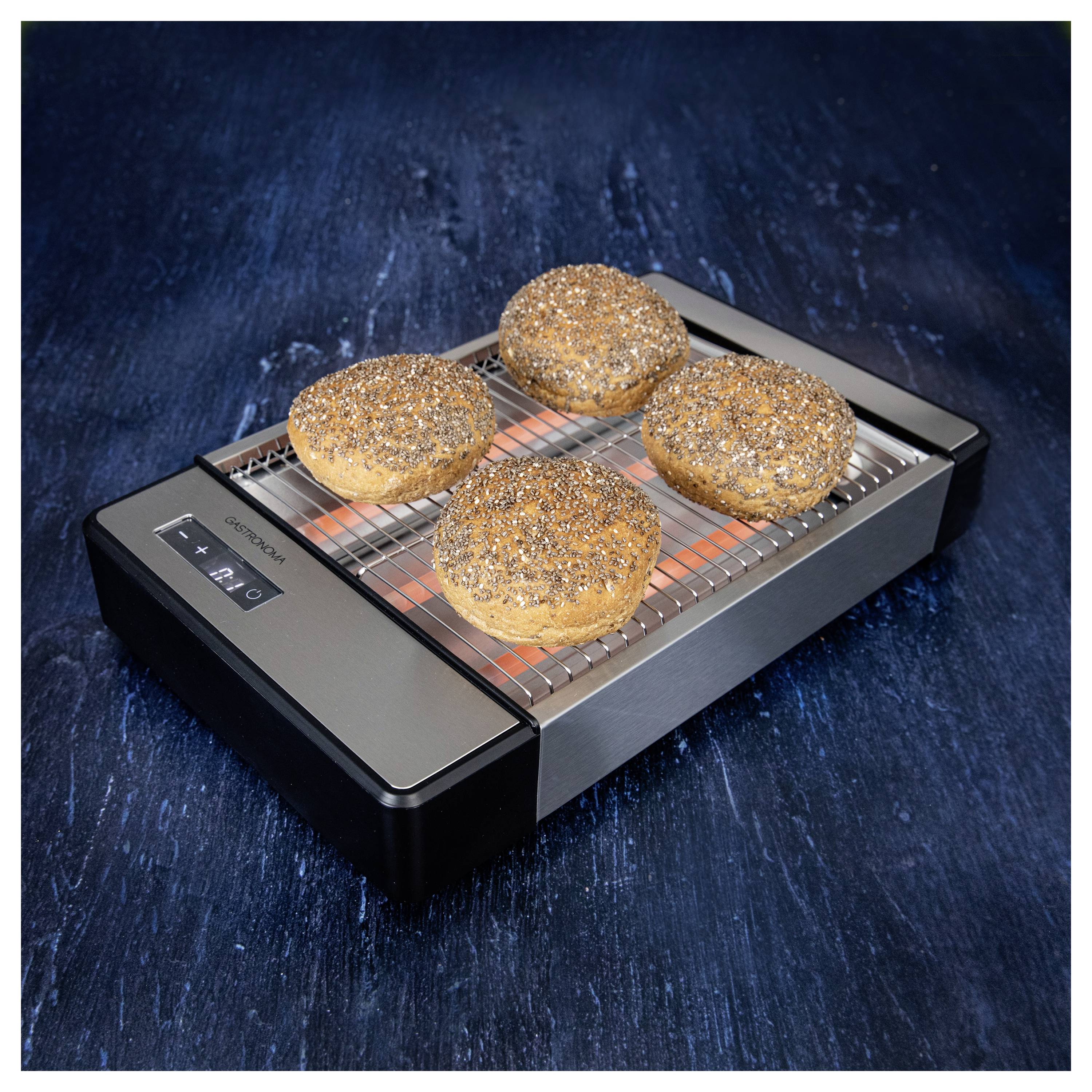 Un grille-pain 'Toastess Classic' doré grillant quatre bagels aux graines de pavot sur une surface texturée bleue.