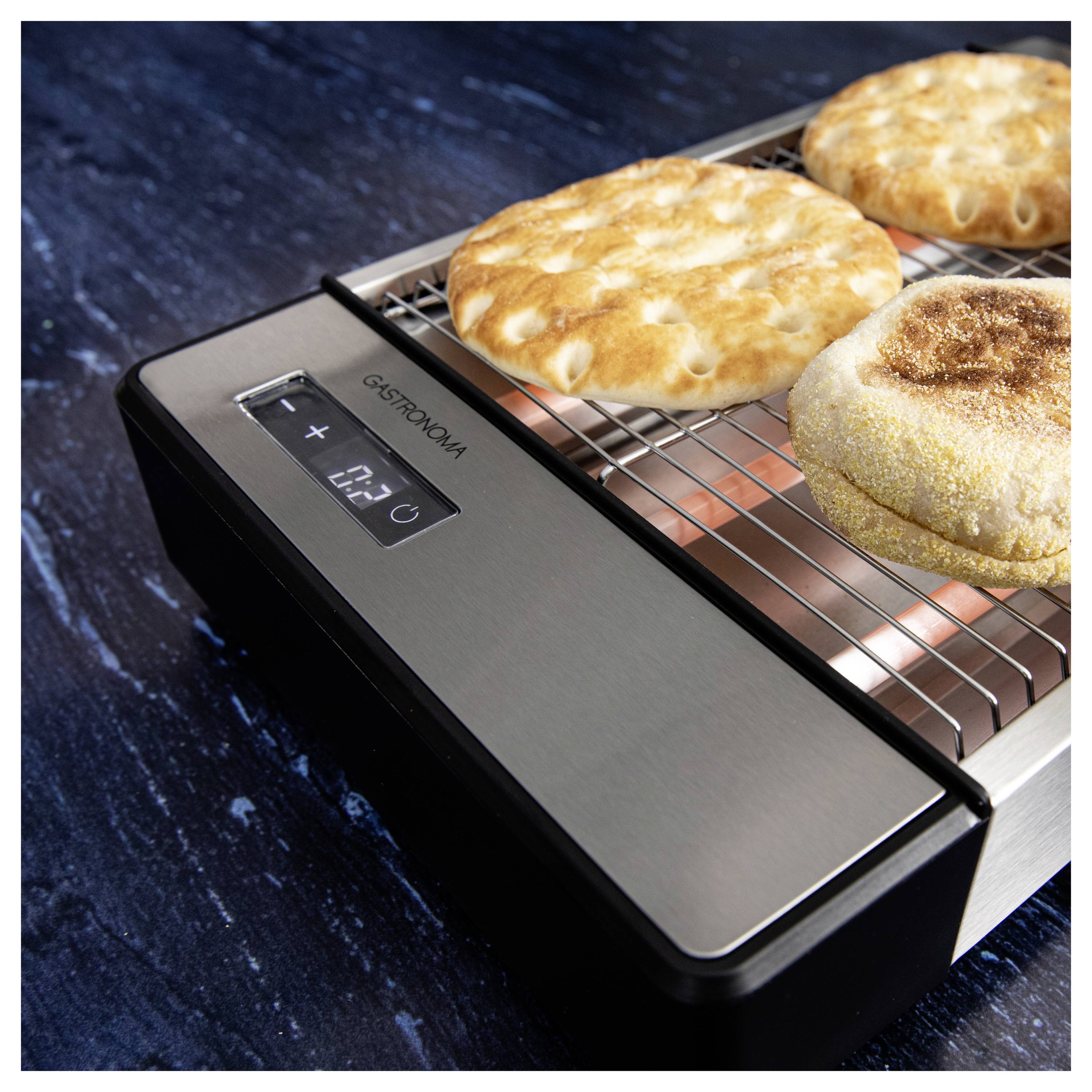 Un four de comptoir cuisant du pain plat avec un brunissement visible en surface. L'affichage montre la température, indiquant un processus de cuisson en cours.