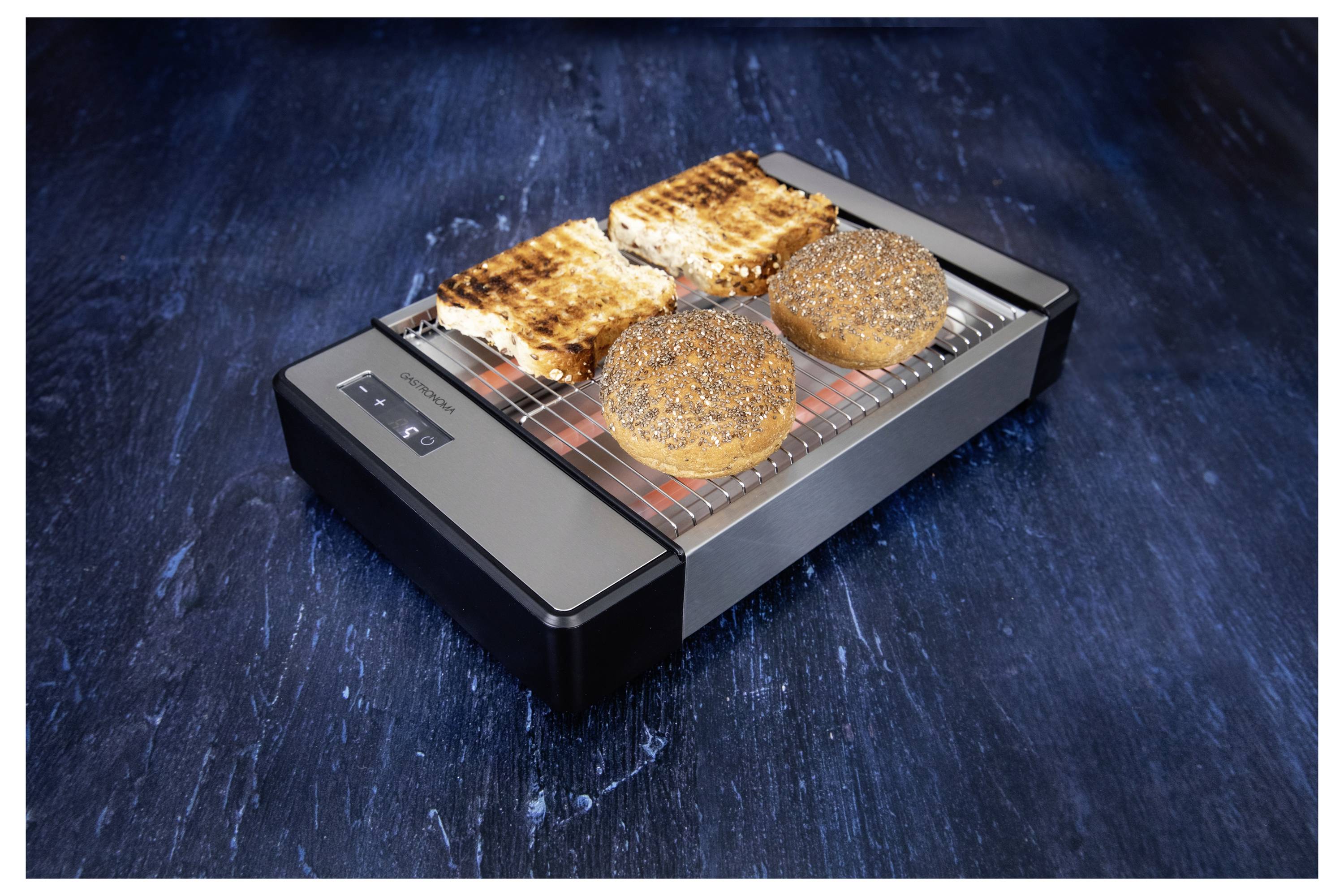 Vue de dessus d'un grille-pain présentant deux tranches de sandwich grillées et deux petits pains parsemés de graines de pavot sur une surface bleu foncé.